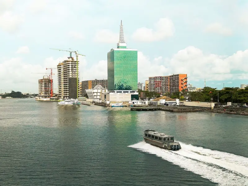 A motorboat crossing Lagos Lagoon past Civic Centre Towers, Victoria Island